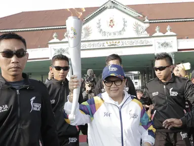 Menteri Luar Negeri, Retno Marsudi, menjadi pelari pertama kirab obor Asian Games 2018 di Pagelaran Keraton Yogyakarta, Kamis (19/7/2018). Total jarak kirab Obor di Yogya ini sepanjang 11,5 kilometer. (Bola.com/M Iqbal Ichsan)