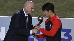 Presiden FIFA, Gianni Infantino (kiri) menyerahkan trofi Bronze Ball Award kepada gelandang Korea Selatan, Lee Seungwon setelah laga final Piala Dunia U-20 2023 antara Uruguay menghadapi Italia di Unico Diego Armando Maradona Stadium, La Plata, Argentina, Senin (12/6/2023) dini hari WIB. Lee Seungwon menempati posisi ketiga sebagai pemain terbaik turnamen dan mampu menyumbang 3 gol bagi Korea Selatan. (AFP/Luis Robayo)