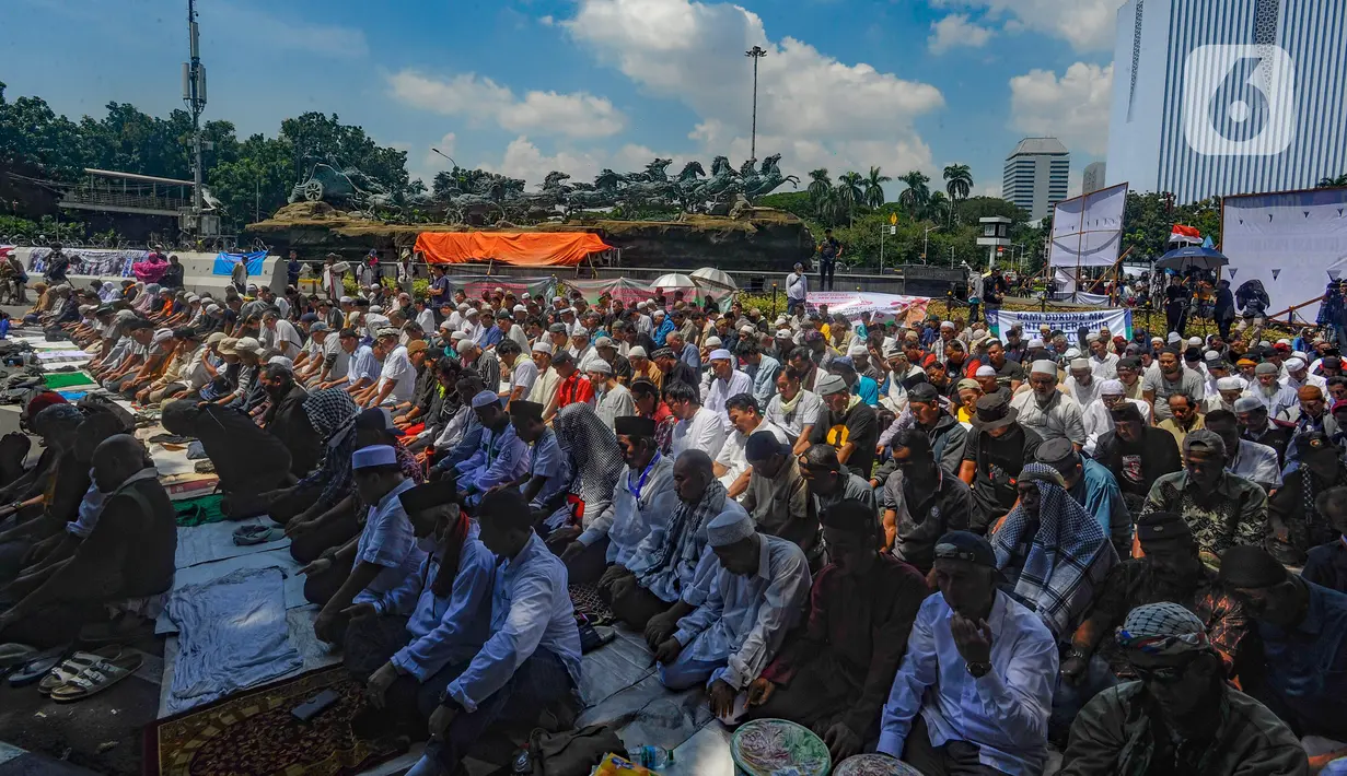 Massa aksi kawal putusan Mahkamah Konstitusi (MK) terkait sengketa hasil Pilpres 2024 melaksanakan salat zuhur berjemaah di sekitar Patung Kuda Arjuna Wiwaha, Monas, Jakarta Pusat, Senin (22/4/2024). (merdeka.com/Arie Basuki)