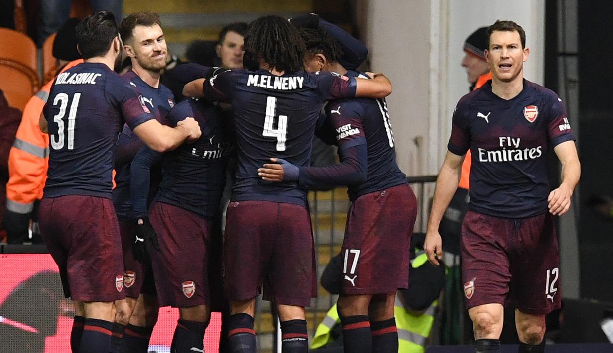 Para pemain Arsenal merayakan gol yang dicetak oleh Alex Iwobi ke gawang Blackpool pada laga Piala FA di Stadion Bloomfield Road, Sabtu (5/1). Arsenal menang 3-0 atas Blackpool. (AFP/Paul Ellis)