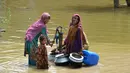 Wanita yang terkena banjir mengisi air minum dari pompa tangan di tengah jalan yang banjir setelah hujan lebat di distrik Jaffarabad di provinsi Balochistan (29/8/2022). Jumlah korban tewas akibat banjir monsun di Pakistan sejak Juni telah mencapai 1.136, menurut angka yang dirilis pada 29 Agustus oleh Otoritas Manajemen Bencana Nasional negara itu. (AFP/Fida Hussain)