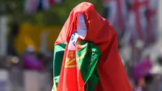 Pelari putri asal Portugal, Ines Henriques menutup tubuhnya dengan bendera negaranya setelah memenangkan medali emas dalam lomba lari putri selama Kejuaraan Atletik Dunia di London, Inggris (13/8). (AP Photo / Martin Meissner)