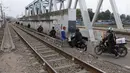 Suasana saat sejumlah pengendara melintas di samping rel kereta yang berada di kawasan Banjir Kanal Barat, Jakarta, Selasa (20/3). Mereka beralasan hal itu dilakukan demi mempersingkat waktu. (Liputan6.com/Arya Manggala)