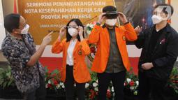 Rektor Unika Atma Jaya Dr. Agustinus Prasetyantoko (kiri) dan CEO dan Founder dari WIR Group, Michael Budi (kanan) saat menyaksikan uji coba kacamata virtual reality di Kampus Semanggi,  Jakarta, Senin (21/3/2022). (merdeka.com/Arie Basuki)