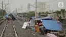 Pengungsi banjir mendirikan tenda di jalur rel kereta commuterline Tangerang-Duri di Kembangan Baru, Jakarta, Jumat (3/1/2020). Jalur rel yang nonaktif sementara karena banjir dimanfaatkan warga sekitar untuk mendirikan tenda darurat karena rumah mereka masih terendam. (Liputan6.com/Faizal Fanani)