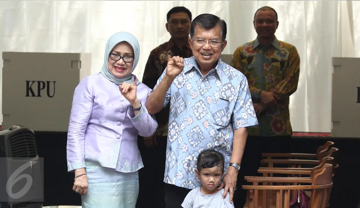 Wakil Presiden Jusuf Kalla (JK) didampingi istri, Mufidah Kalla, menunjukkan jari yang sudah dicelupkan ke tinta setelah melakukan pencoblosan Pilkada DKI 2017 di TPS 03 Kelurahan Pulo, Jakarta Selatan, Rabu (19/4). (Liputan6.com/Herman Zakharia)