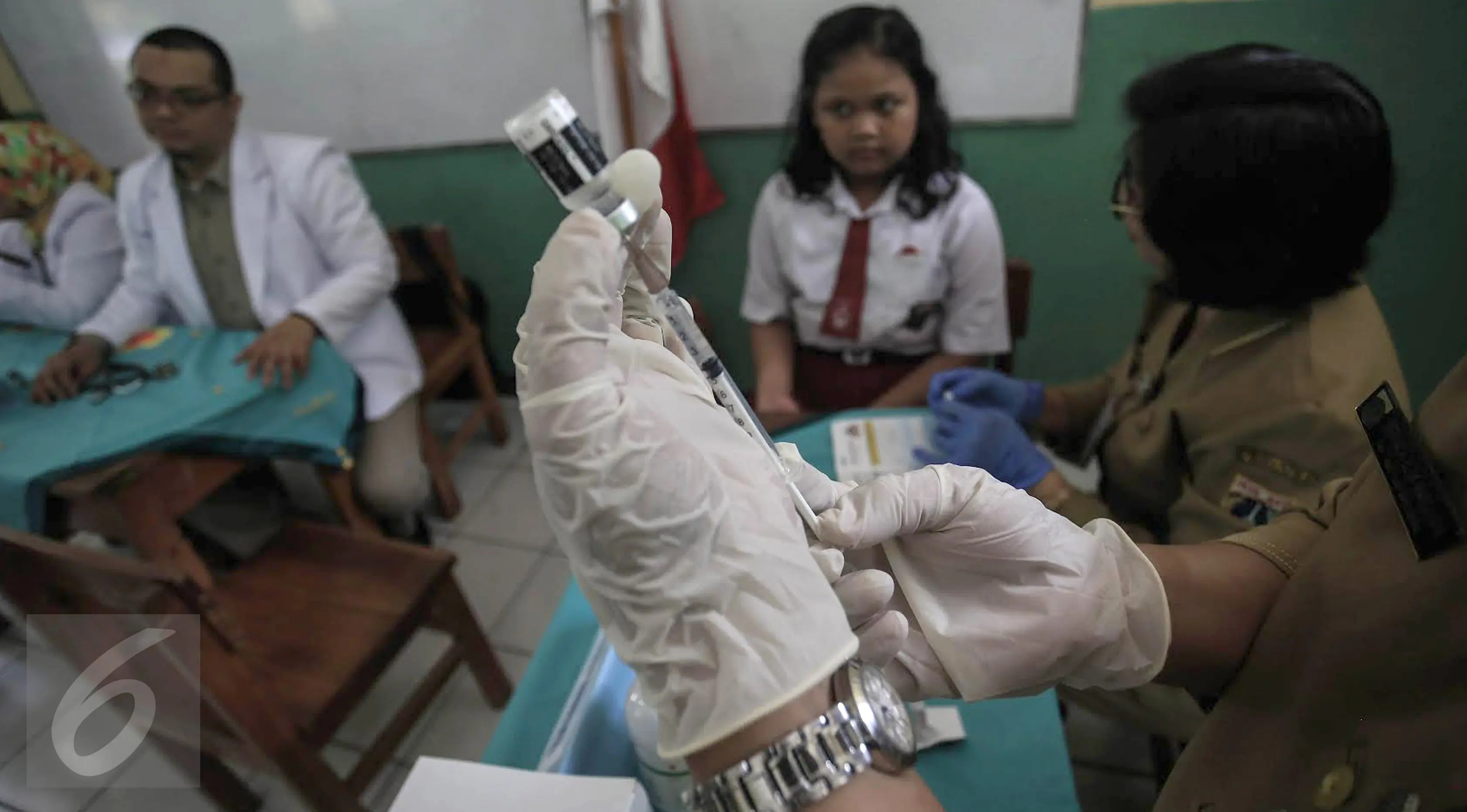 Dokter bersiap memberikan suntikan imunisasi di SDN 11 Pagi, Lubang Buaya, Jakarta, Selasa (4/10). Kegiatan ini untuk mewujudkan Indonesia bebas dari kanker serviks. (Liputan6.com/Faizal Fanani)