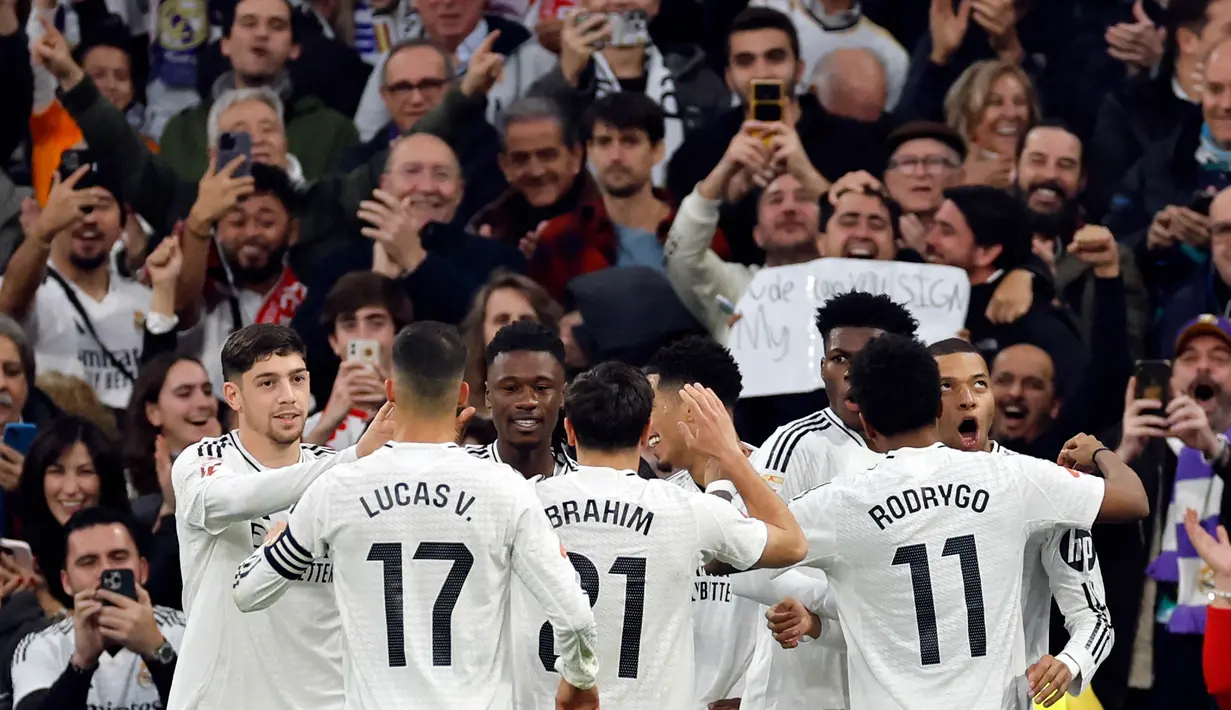 Penyerang Real Madrid, Kylian Mbappe (kanan) merayakan golnya saat laga pekan ke-18 La Liga 2024/2025 melawan Sevilla FC di Stadion Santiago Bernabeu, Madrid, 22 Desember 2024. (OSCAR DEL POZO/AFP)