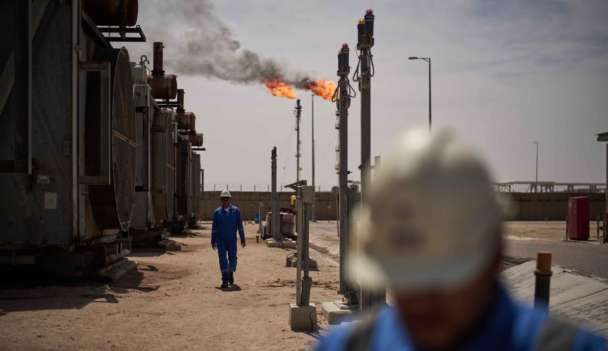 Para pekerja berjalan di area stasiun degasifikasi di ladang minyak Zubair, yang operasinya telah dikurangi karena perang Timur Tengah yang dipicu oleh serangan AS dan Israel terhadap Iran, dekat Basra, Irak, Sabtu, 28 Maret 2026. Ketegangan antara Iran, Israel, dan Amerika Serikat, yang terus memanas sejak akhir Februari 2026 memicu ancaman krisis energi secara global. (AP Photo/Leo Correa)