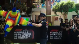 Pembalap Red Bull Racing, Max Verstappen bermain pukul pinata pada rangkaian acara menjelang Formula 1 GP Meksiko 2023 di paddock Sirkuit Hermanos Rodriguez, Meksiko, Kamis (26/10/2023) waktu setempat. (AFP/Claudio Cruz)