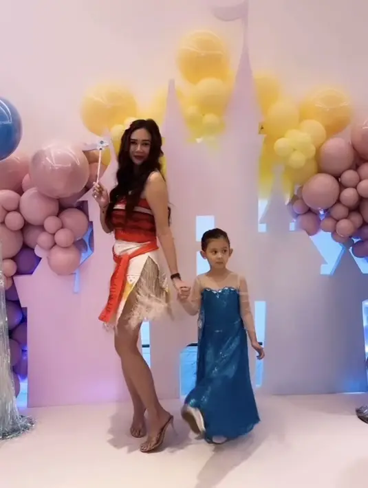 Gaun biru tersebut dipadukan flat shoes putih, si kecil tampil dengan gaya rambut ikat belakang yang cukup rapi. [@aurakasih]