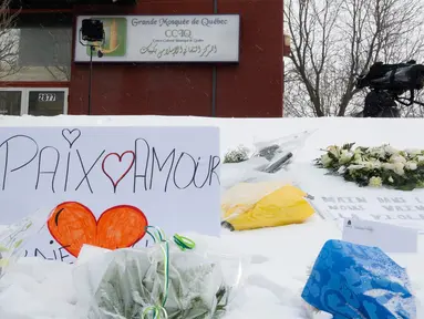 Sejumlah bunga berada di depan Masjid Quebec setelah penembakan brutal yang menewaskan jemaah masjid di Quebec, Kanada, (2/2). Akibatnya penembakan enam orang tewas dan 12 orang lain menderita luka ringan. (Jacques Boissinot/The Canadian Press via AP)