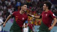 Penyerang Portugal Cristiano Ronaldo berselebrasi dengan rekan setimnya Joao Felix setelah mencetak gol pembuka timnya melalui penalti ke gawang Ghana pada duel grup H Piala Dunia 2022 di stadion 974, Kamis (24/11/2022). Cristiano Ronaldo mencetak satu gol dalam kemenangan 3-2 Portugal atas Ghana. (AP Photo/Manu Fernandez)