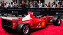 Pengunjung melihat mobil mantan pembalap Ferrari F1 dari Jerman, Michael Schumacher saat dipamerkan di perayaan ulang tahun Ferrari ke-70 di Rockefeller Plaza, New York, AS (8/10). (AFP Photo/Jewel Samad)
