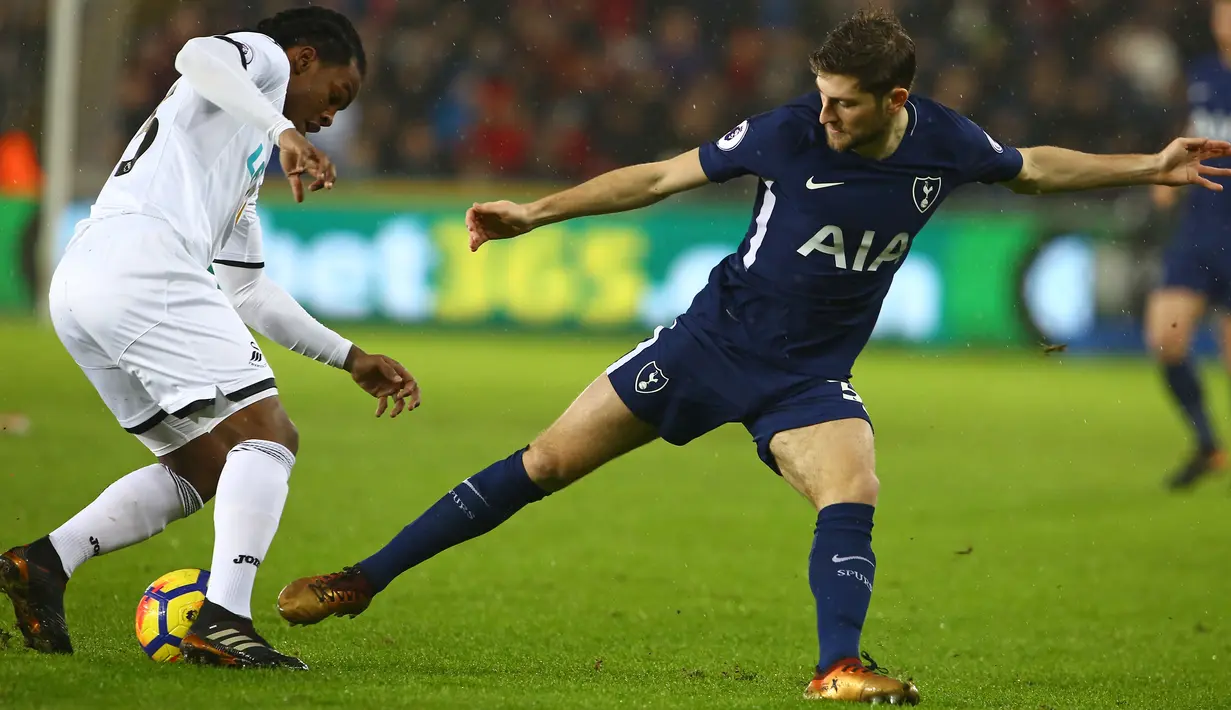 Pemain Swansea City, Renato Sanches berebut bola dengan bek Tottenham Hotspur, Ben Davie pada laga pekan ke-22 Premier League di Stadion Liberty, Selasa (2/1).Tottenham Hotspur memetik kemenangan 2-0 atas tuan rumah Swansea City. (Geoff CADDICK / AFP)