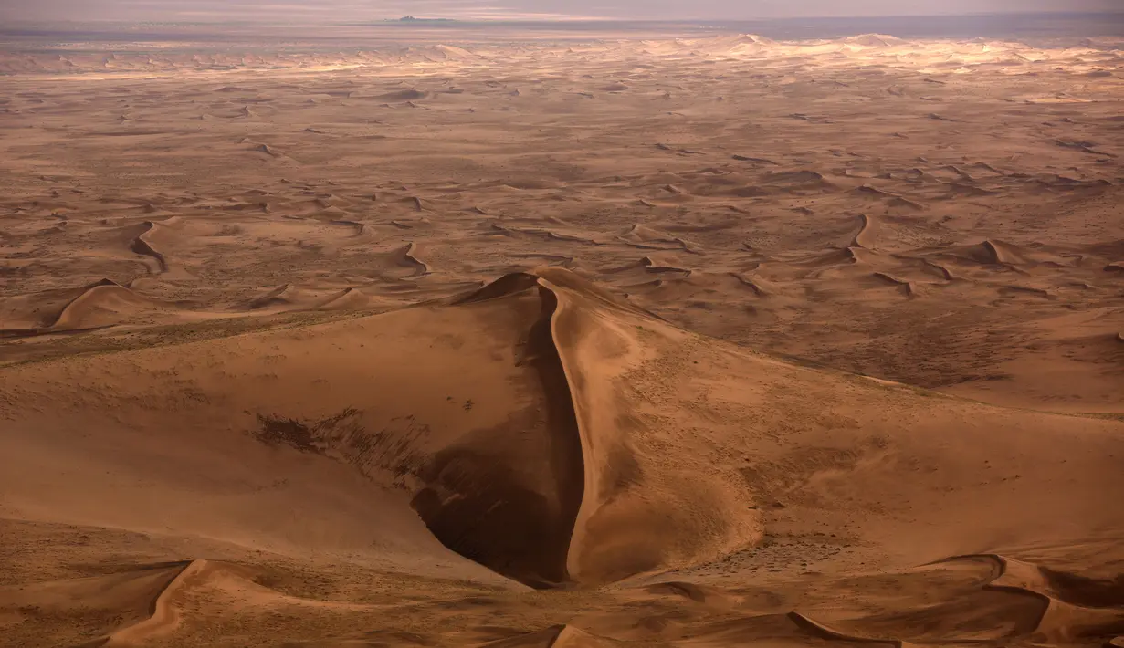 Pandangan dari udara sebuah bukit dikelilingi hamparan pasir Gurun Gobi wilayah Mongolia (21/7). Gurun terbesar di Asia ini sangat menakjubkan ketika dilihat dari udara. (AFP PHOTO / PATRICK BAZ)