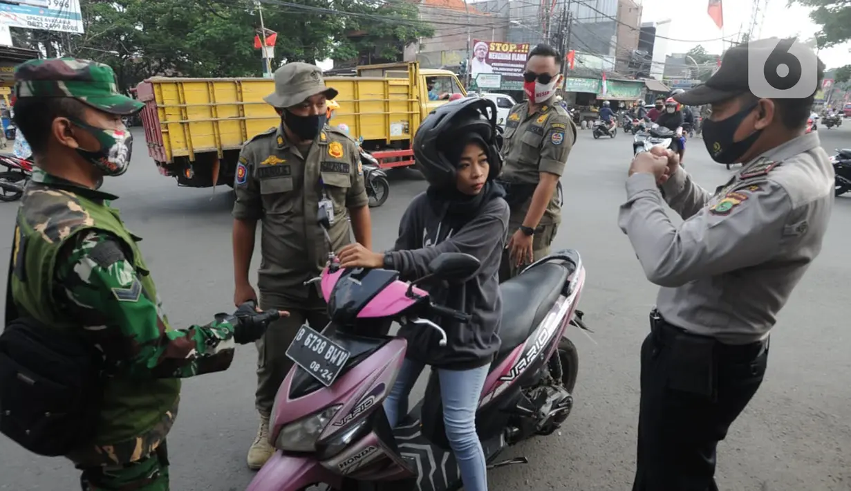 Anggota TNI-Polri menghentikan warga yang tidak mengenakan masker saat razia gabungan Kelurahan Gandul di Perempatan Gandul, Cinere, Depok, Kamis ( 29/08/2020). (merdeka.com/Arie Basuki)