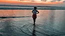 Suka traveling ke alam mulai dari pantai hingga air terjun, Ria Andrews percaya diri dengan warna kulit eksotis. Kini menetap di Bali, Ria Andrews memang sering bagikan foto keindahan Pulau Dewata, Bali. Seperti salah satunya saat ia liburan di pantai sembari melihat keindahan sunset di langit Bali ini yang diunggah di laman Instagram pribadinya pada tahun 2021. (Liputan6.com/IG/ria.travelwithmeri)
