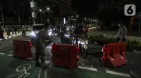 Petugas gabungan berjaga saat berlangsungnya Crowd Free Night di kawasan Bundaran HI, Jakarta, Jumat (31/12/2021). Polda Metro Jaya memberlakukan pengendalian mobilitas Crowd Free Night pada malam Tahun Baru 2022 yang berlangsung mulai pukul 22.00-04.00 WIB. (Liputan6.com/Johan Tallo)