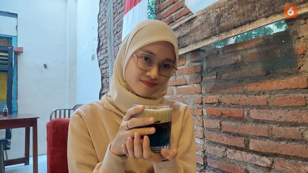 Salah seorang pengunjung sedang menikmati  Minuman Blue Fire (Hermawan Arifianto/Liputan6.com)