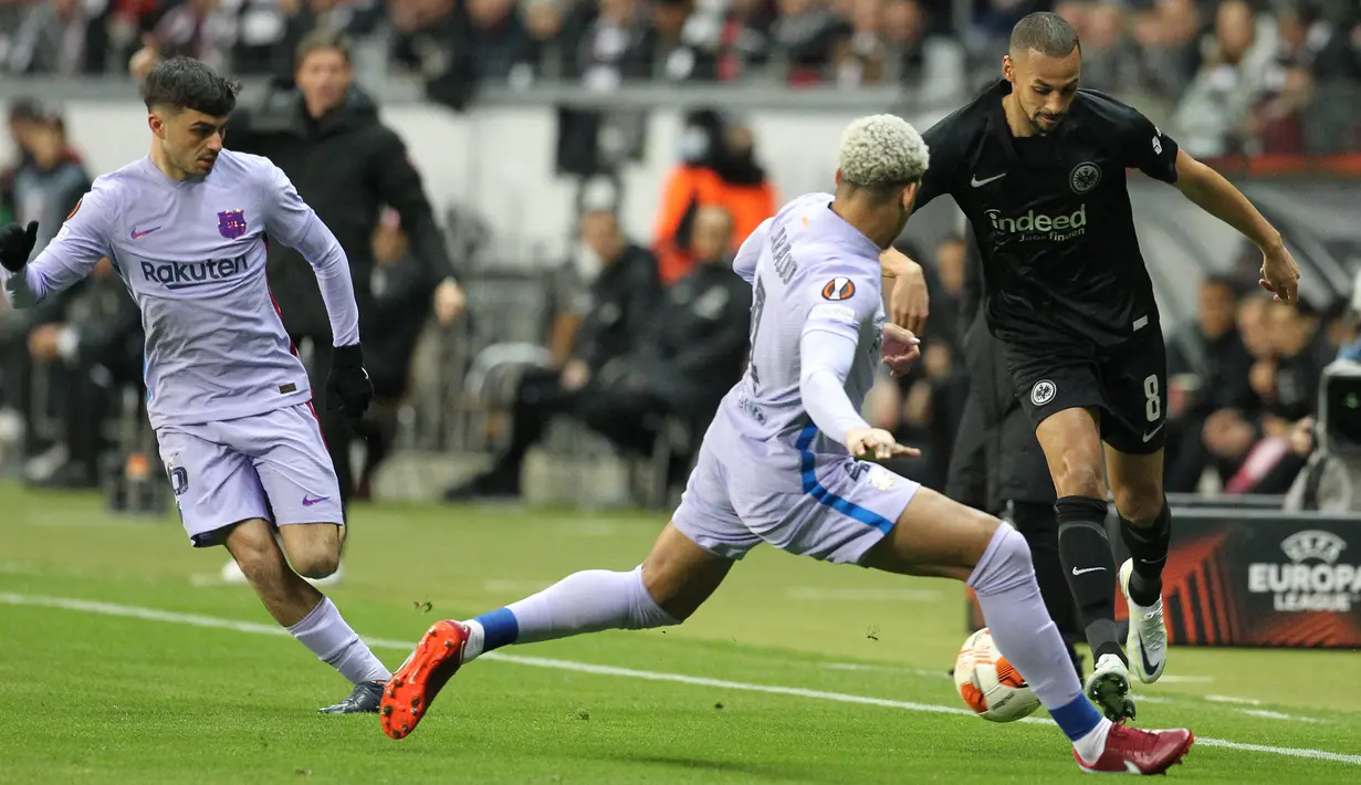 Gelandang Eintracht Frankfurt Djibril Sow (kanan) berebut bola dengan bek Barcelona Ronald Araujo pada laga leg pertama perempat final Liga Europa 2021/22 di Deutsche Bank Park, Jumat dini hari WIB (8/4/2022). Frankfurt dan Barcelona berbagi skor 1-1. (Daniel ROLAND / AFP)