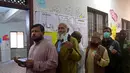 Para pemilih berdiri dalam antrian menunjukkan kartu identitas pemilih mereka di Karachi pada tanggal 8 Februari 2024. (Asif HASSAN/AFP)