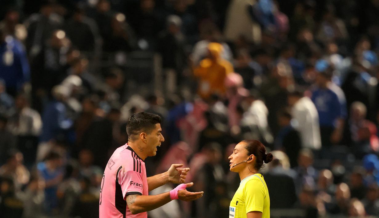 Pemain Inter Miami, Luis Suarez (kiri) memprotes keputusan wasit pada laga persahabatan melawan Al-Hilal yang berlangsung di Kingdom Arena Stadium, Riyadh, Arab Saudi, Selasa (30/01/2024) WIB. Gol Suarez sempat tidak disahkan oleh wasit karena dianggap offside. (AFP/Fayez Nureldine)