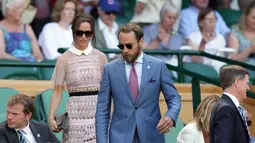 Pippa Middleton ditemani adiknya, James Middleton, menuju kursi untuk menyaksikan kejuaraan tenis Grand Slam Wimbledon 2017 di London, Rabu (5/7). Pippa hadir dalam balutan mini-dress berwarna dusty pink dari label Self-Potrait. (AP Photo/Tim Ireland)