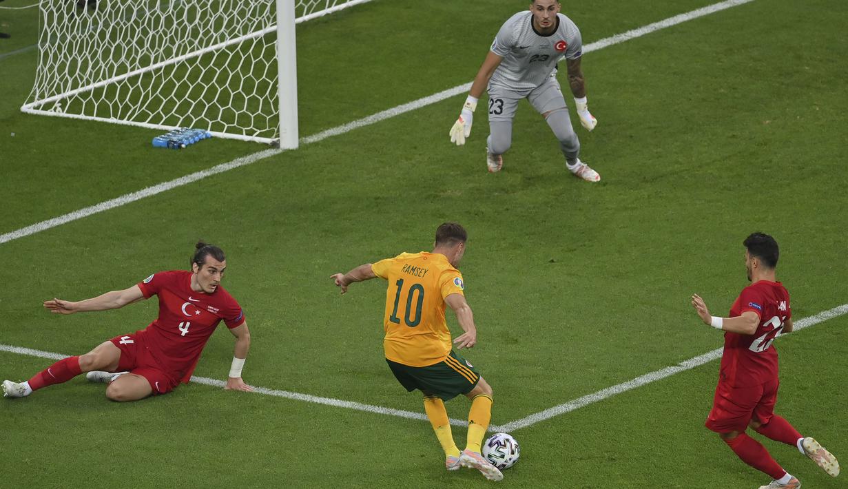 Pada menit keempat Aaron Ramsey mendapatkan peluang pertama lewat kerjasama apik bersama Gareth Bale. Sayangnya Ramsey tak mampu mengkonversi umpan Bale berkat kesigapan Ugurcan Cakir yang menghalau bola menggunakan kakinya. (Foto: AP/Pool/Dan Mullan)