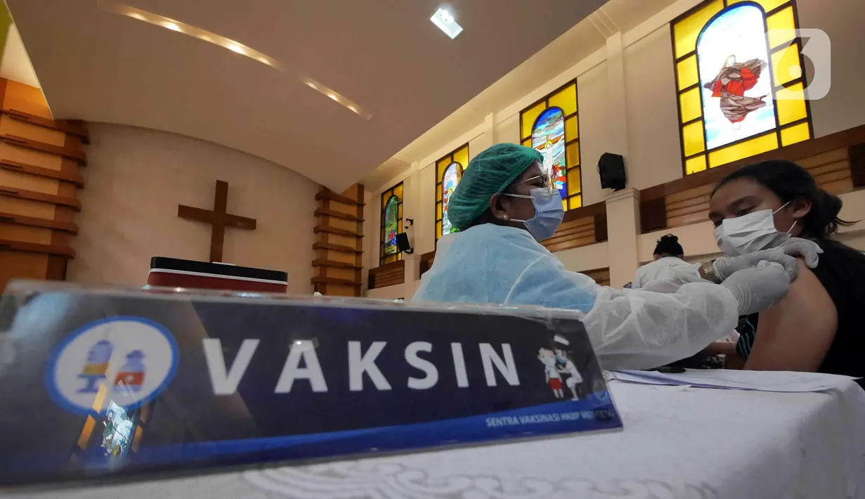 Petugas kesehatan menyuntikkan vaksin COVID-19 penguat (booster) atau dosis ketiga di Gereja Huria Kristen Batak Protestan Menteng Anno 1955, Jakarta Pusat, Selasa (25/1/2022). Vaksinasi digelar setiap Senin-Jumat sampai tanggal 5 Februari 2022. (Liputan6.com/Herman Zakharia)