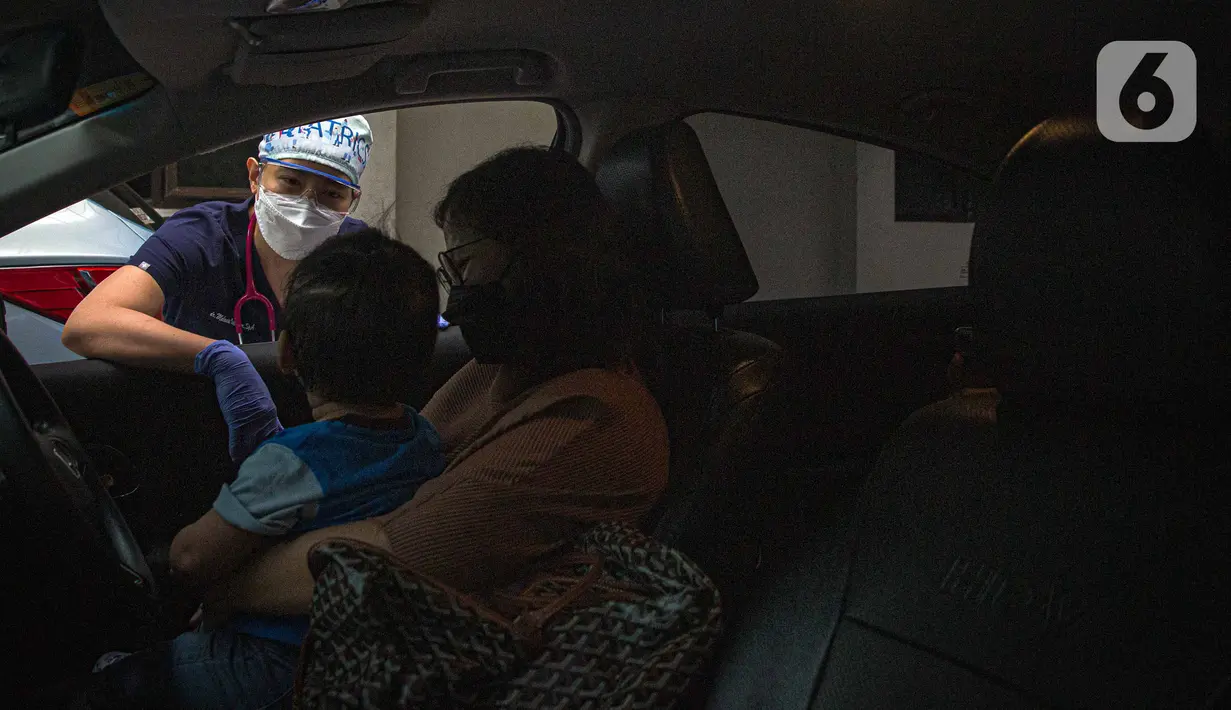 Petugas memeriksa kesehatan serta imunisasi pasien anak di RSIA Bunda, Jakarta, Jumat (18/3/2022). Pemeriksaan dilakukan drive thru guna memberi rasa aman orangtua, khususnya ibu yang ingin melaksanakan imunisasi serta pemeriksaan nonpenyakit di tengah pandemi COVID-19. (Liputan6.com/Faizal Fanani)