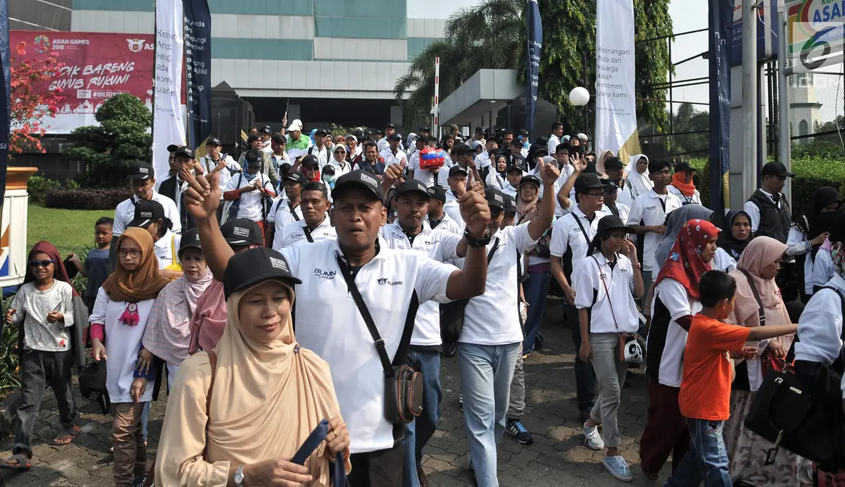 Peserta eserta berjalan menuju bus mudik gratis di depan Kantor PT ASABRI, Jakarta, Minggu (10/6). Program mudik gratis ini merupakan edisi perdana PT ASABRI. (Merdeka.com/Iqbal S. Nugroho)