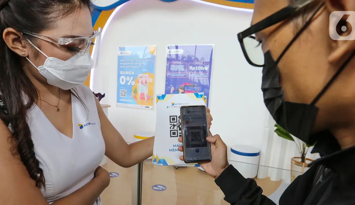Pengunjung mencoba fitur QRIS pada aplikasi AstraPay di pameran GIIAS, ICE BSD City, Tangerang, Senin (15/11/2021). QRIS merupakan program untuk inklusi keuangan dan solusi praktis bagi pengunjung untuk memudahkan membeli makanan dan minuman hingga akesoris kendaraan.  (Liputan6.com/Fery Pradolo)
