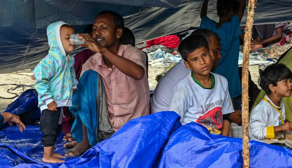 Warga setempat juga terlihat membawa bantuan untuk diberikan kepada para pengungsi. (CHAIDEER MAHYUDDIN/AFP)