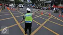 Seorang petugas polisi mengalihkan arus di kawasan Sarinah, Jakarta, Jumat (4/11). Pengalihan ini dilakukan karena aksi 4 November yang memadati tiga titik, yaitu di kantor Bareskrim Polri Balai Kota DKI, dan Istana Negara. (Liputan6.com/Angga Yuniar)