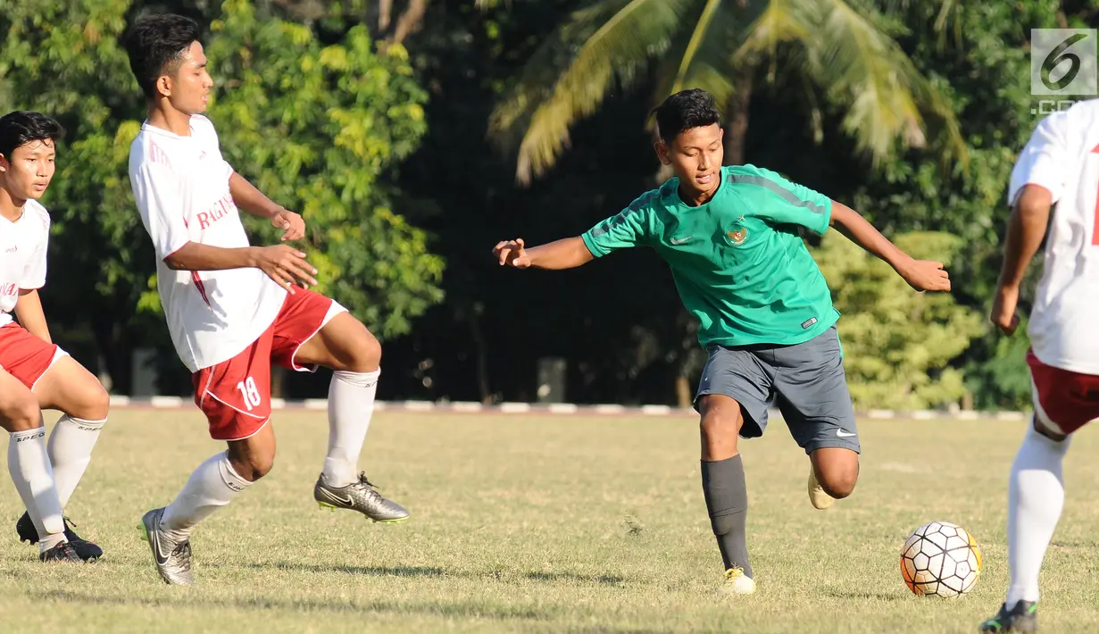 Pemain Timnas Indonesia U-16 (kaus hijau) berebut bola dengan pemain Asian School U-18 di Lapangan Atang Sutresna, Jakarta, Jumat (25/8). Uji tanding ini persiapan jelang kualifikasi Piala Asia U-16, September mendatang. (Liputan6.com/Helmi Fithriansyah)
