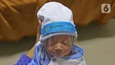 Seorang bayi memakai face shield atau pelindung wajah di Rumah Sakit Ibu dan Anak Tambak, Jakarta, Selasa (14/4/2020). RSIA Tambak sejak 12 April 2020 membuat kebijakan bayi yang baru lahir dipakaikan pelindung wajah untuk mencegah terpapar virus corona COVID-19. (Liputan6.com/Herman Zakharia)