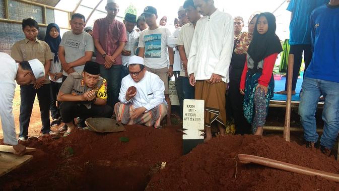Kapolres dan Wakapolres Metro Tangerang, Kombes Harry Kurniawan dan AKBP Harley H. Silalahi, memakamkan santri korban kecelakaan lalu lintas (Liputan6.com/istimewa)