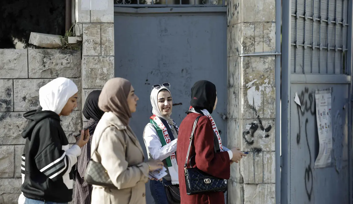 Pemilihan ini merupakan pemilu pertama di wilayah tersebut sejak konflik Israel-Hamas memanas pada Oktober 2023. Tampak dalam foto, perwakilan kandidat Palestina menunggu di luar Tempat Pemungutan Suara (TPS) selama pemilihan kota di Jenin, Tepi Barat yang diduduki Israel, pada Sabtu 25 April 2026. (Marco Longari/AFP)