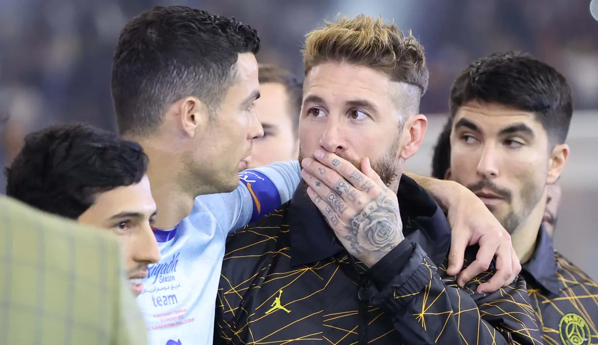 Pemain PSG, Sergio Ramos (tengah) berbincang dengan Cristiano Ronaldo saat laga Riyadh Season Cup antara Riyadh All-Star melawan PSG yang berlangsung di King Fahd Stadium, Riyadh, Jumat (20/1/2023) dini hari WIB. (AFP/Giuseppe Cacace)
