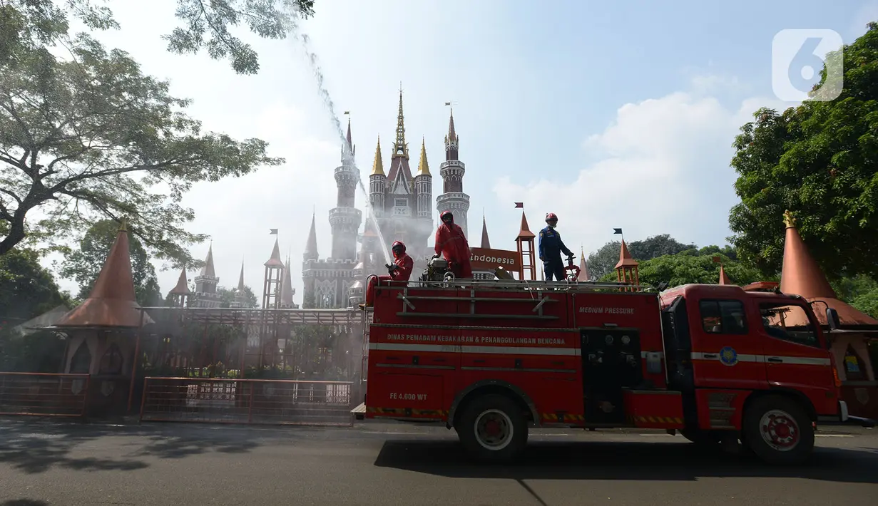 Petugas pemadam kebakaran melakukan penyemprotan cairan disinfektan tempat wisata di Taman Mini Indonesia Indah (TMII), Jakarta, Rabu (10/6/2020). Rencananya, TMII kembali dibuka untuk umum pada 20 Juni 2020 dengan menerapkan tatanan kenormalan baru. (merdeka.com/Imam Buhori)