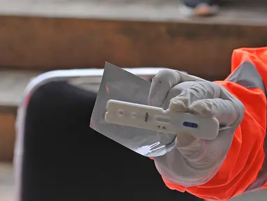 Petugas menunjukkan hasil tes cepat (rapid test) pendektesian COVID-19 kepada tenaga medis di Stadion Patriot Candrabhaga, Bekasi, Jawa Barat, Rabu (25/3/2020). Pemeriksaan hanya diperuntukan bagi tenaga medis seluruh puskesmas, dan rumah sakit yang ada di Kota Bekasi. (Liputan6.com/Herman Zakharia)