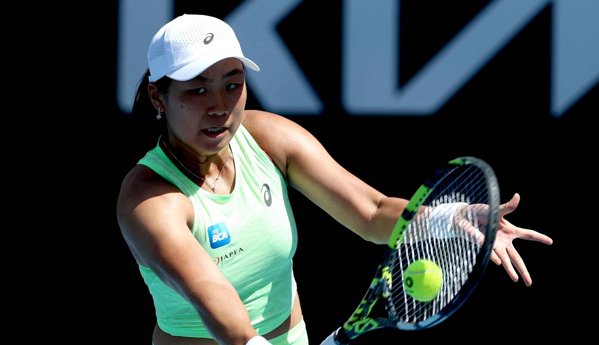 Kali ini petenis andalan Indonesia itu mengejutkan pencinta tenis dunia dengan menyingkirkan Leylah Fernandez dari Kanada dalam babak pertama Australia Open 2026. Tampak dalam foto, petenis Indonesia Janice Tjen memukul bola balasan dari petenis Kanada Leylah Fernandez selama pertandingan tunggal putri hari ketiga turnamen tenis Australia Terbuka di ANZ Arena, Melbourne Park, pada 20 Januari 2026. (DAVID GRAY/AFP)
