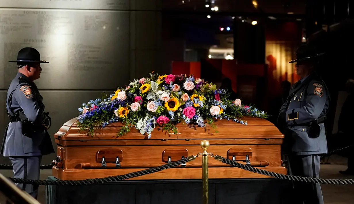 Keluarganya dan anggota serta mantan anggota keamanan Dinas Rahasia AS ikut dalam iring-iringan mobil jenazah pada Senin pagi ke Kompleks Ilmu Pengetahuan dan Kesehatan Rosalynn Carter di Georgia Southwestern State University di Americus, Georgia, di mana karangan bunga diletakkan. (AP Photo/Brynn Anderson, Pool)