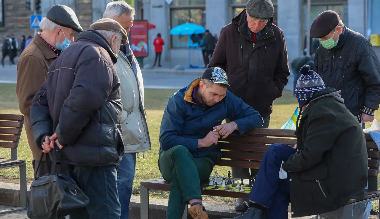 Para pria bermain catur di bangku kawasan pusat pejalan kaki di Kota Lviv, Ukraina, 20 Maret 2022. Kota Lviv menganggap dirinya sebagai pusat budaya Ukraina. (Alexey Filippov/AFP)