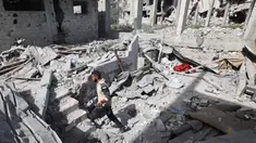 Seorang pria Palestina berjalan di antara reruntuhan bangunan di daerah yang menjadi sasaran serangan Israel di Khan Yunis di Jalur Gaza selatan, pada 2 April 2025. (Eyad BABA/AFP)