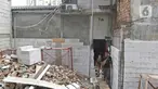 Salah satu kerabat pemilik rumah saat keluar dari rumah di kawasan Mangga Dua Dalam, Jakarta, Kamis (12/12/2019). Sebuah rumah di kawasan Mangga Dua terhimpit oleh bangunan yang sedang dibangun. (Liputan6.com/Herman Zakharia)