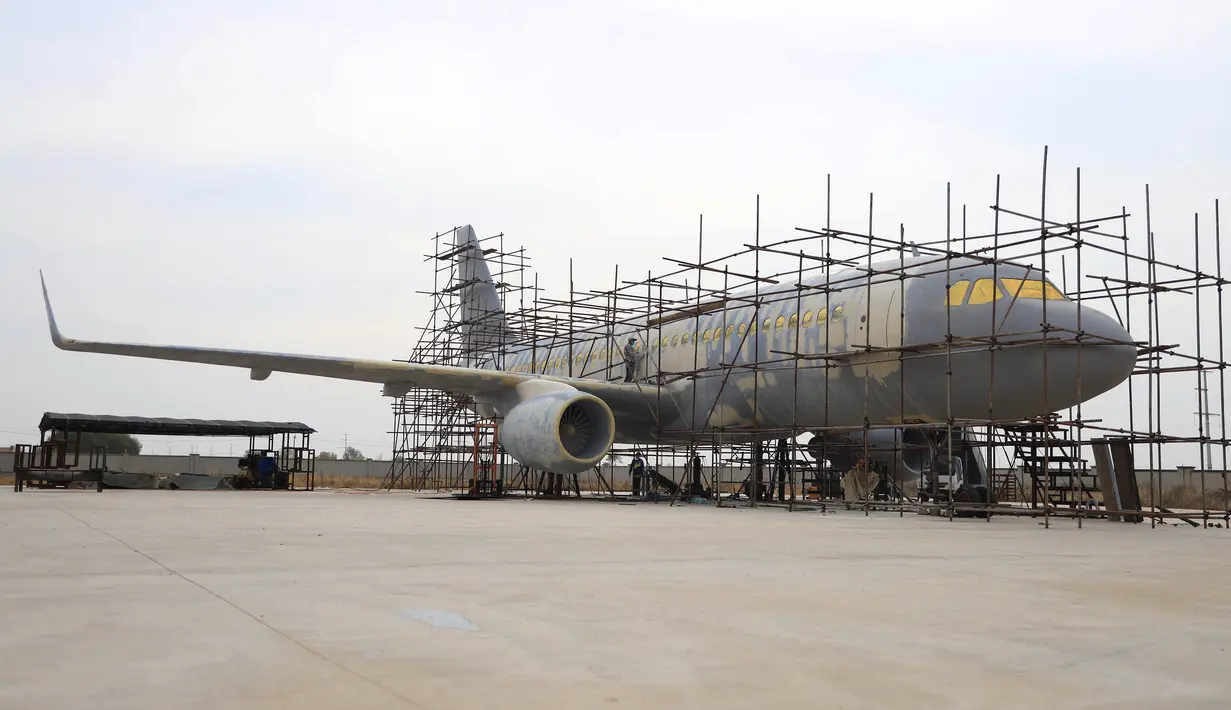 Orang-orang menyelesaikan pembuatan replika pesawat Airbus A320 skala penuh di Kaiyuan, timur laut China, 25 Oktober 2018. Replika pesawat Airbus A320 yang hampir selesai itu diparkir permanen di sepetak lahan yang dikelilingi ladang gandum. (STR/AFP)