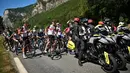 Rombongan pebalap dihentikan semenatara oleh regulator balapan karena terjadi demonstrasi perubahan iklim yang menutup rute balapan pada etape ke-10 Tour de France, antara Morzine dan Megeve, di Pegunungan Alpen Prancis, pada 12 Juli 2022. (AFP/Marco Bertorello)