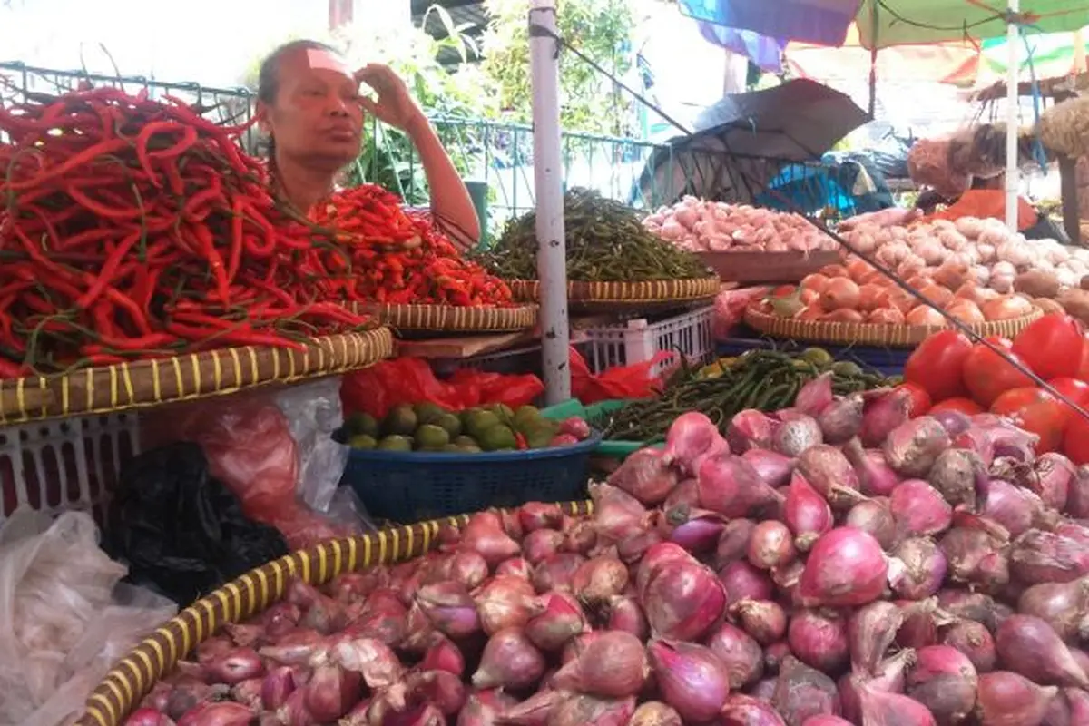 Seorang pedagang sayur di Pasar Kebayoran, Jakarta Selatan, Jumat (9/2/2018). (Maul/Liputan6.com)